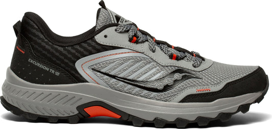 A gray and black athletic shoe with orange accents. The words EXCURSION TR 15 are visible on the heel.