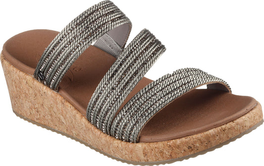 Slide sandals with three silver and black braided straps and a tan cork wedge heel.