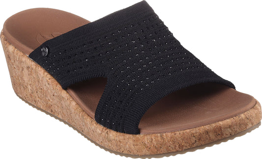 Black wedge sandal with a wide woven upper strap decorated with small round studs and a cork platform sole.