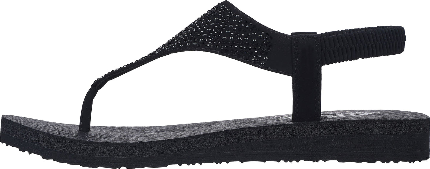 A black, flat sandal with a T-strap and elastic back strap.