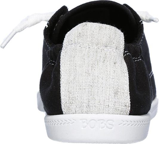 The back view of a black canvas shoe with white laces and a white sole, and a gray heel panel.