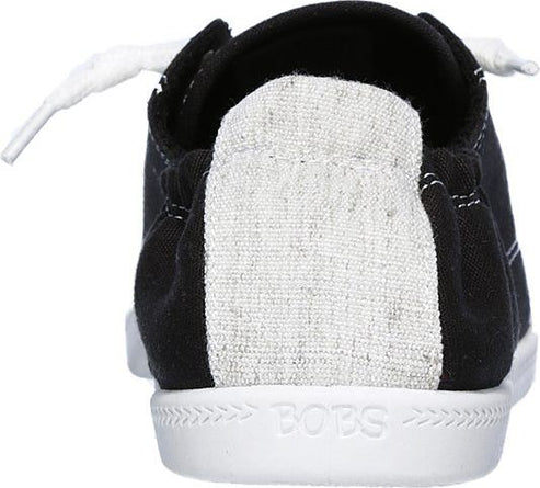 The back view of a black canvas shoe with white laces and a white sole, and a gray heel panel.
