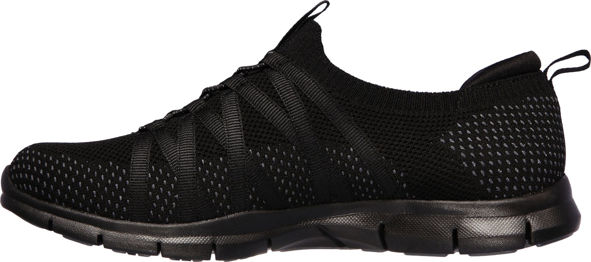 A black slip-on sneaker with a mesh upper and black sole.