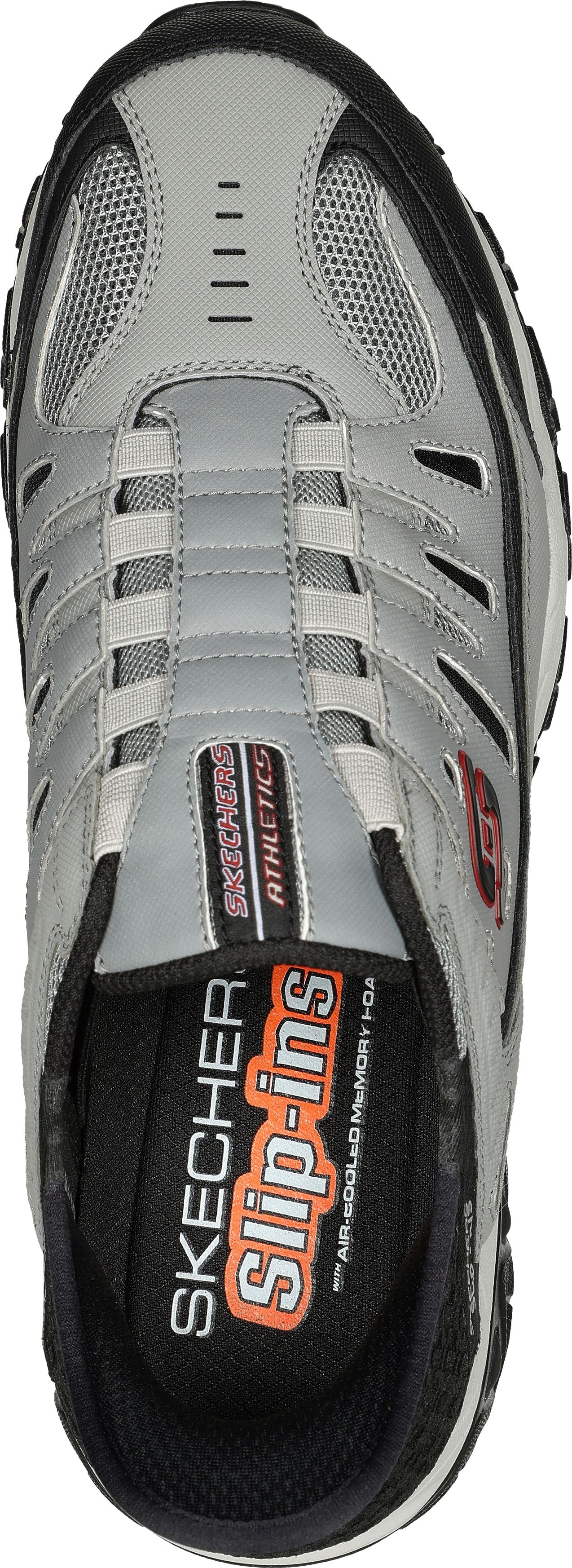 Overhead view of a gray sneaker with black trim and a gray mesh toe. "SKECHERS Slip-ins" text is inside the shoe.