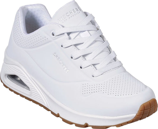 White sneaker with brown sole and visible air pocket.