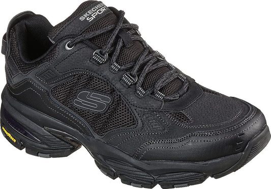 Low-top black athletic shoe with mesh panels, lace-up closure and the letter 'S' on the side.