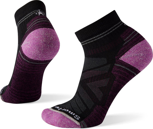 Two athletic socks: one ankle sock shows its sole, ankle and heel; the other is side-on and shows its ankle, arch and toe box. The socks are black with purple-pink heels and toes and have grey stripes around the ankle.