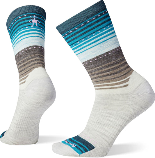 Pair of crew socks, white with striped design fading from brown to blue; small embroidered pink creature on the side.