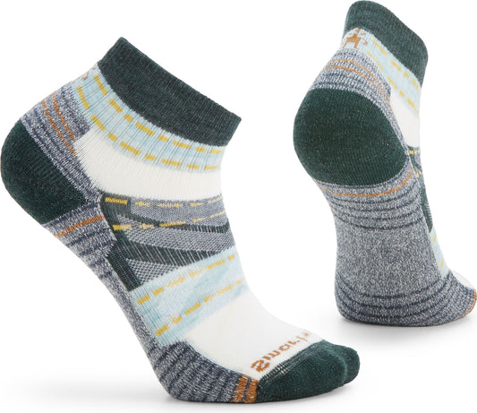 Pair of ankle-length socks with colorful geometric pattern; green at toe, heel and ankle; white midsection.