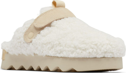 Beige furry slipper with velcro strap and sawtooth platform sole.