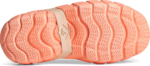 Close-up view of a shoe's peach-colored sole with a wavy pattern and a light-brown strap bearing a logo.