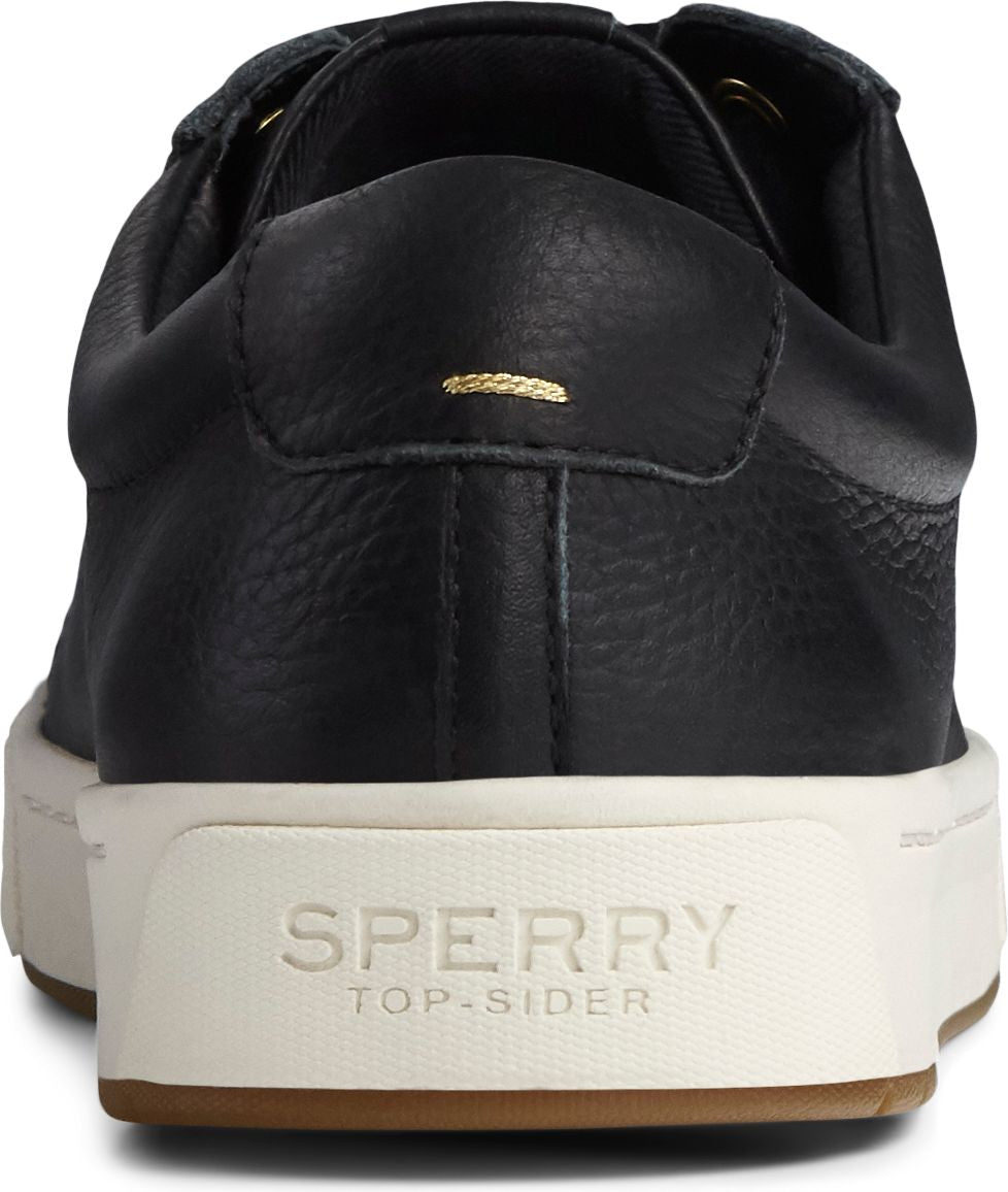 Back of a black leather sneaker with white sole and a gum-colored outsole. The brand's name, SPERRY TOP-SIDER, is printed on the heel area.