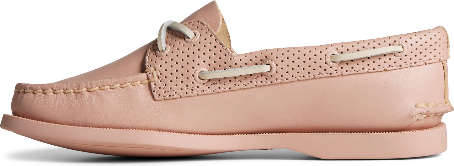 A pink boat shoe with perforated detailing.