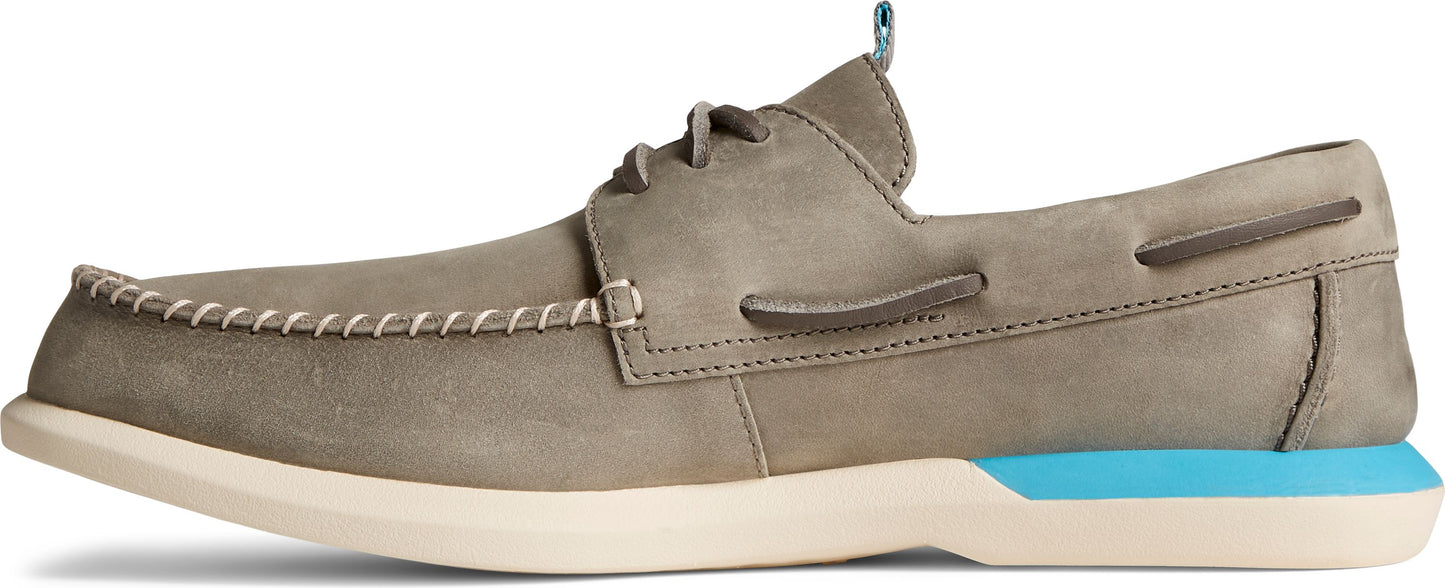 A tan boat shoe with a light tan sole and blue heel accent.