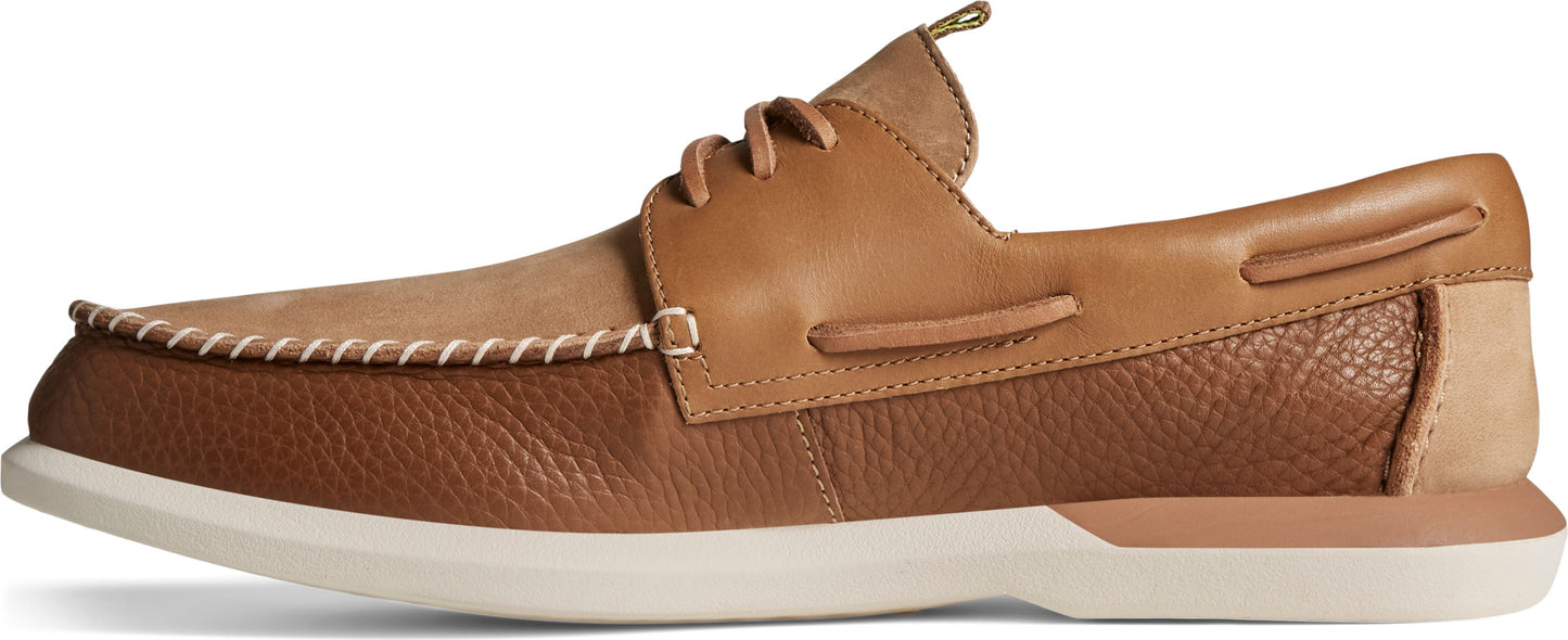 A pair of brown leather boat shoes with white soles.