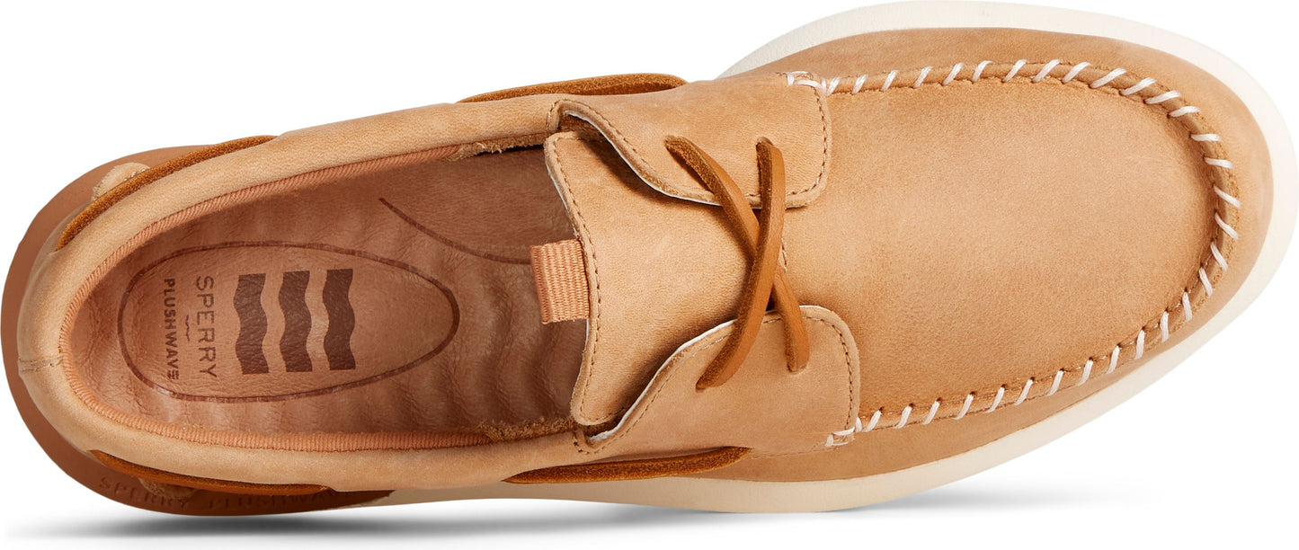 A tan boat shoe with white stitching around the toe.