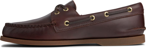 A brown leather boat shoe with moccasin toe stitching and gold eyelets.