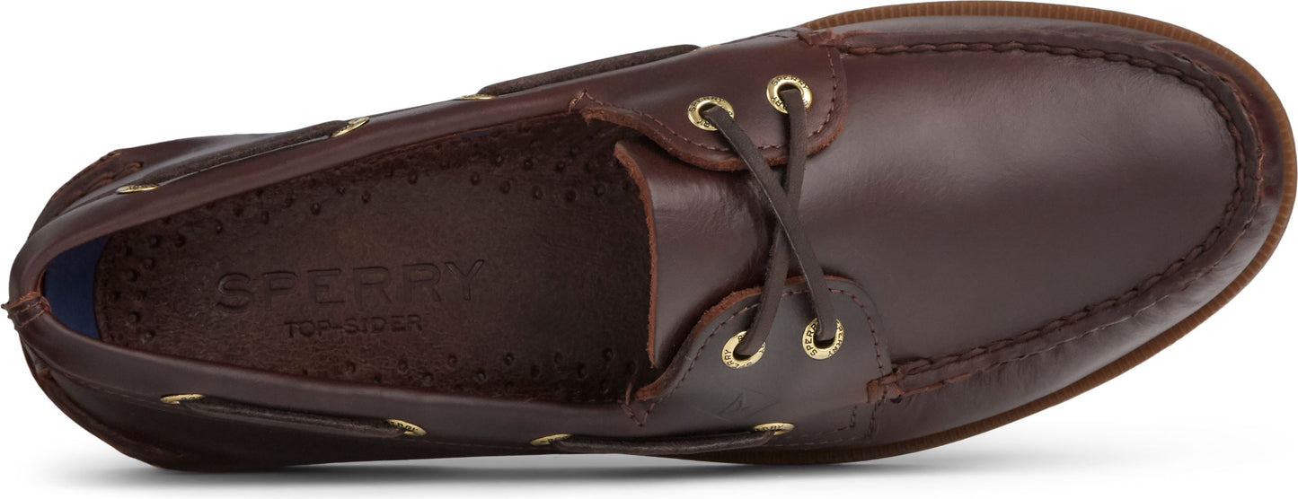 A brown boat shoe with gold eyelets and leather laces.