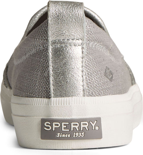 Back view of a silver casual sneaker with a white rubber sole and a silver metallic heel strap, showcasing the word 'SPERRY' and 'Since 1935' on the heel.
