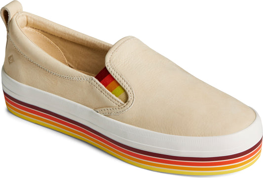Beige leather slip-on sneaker with a thick white sole with horizontal red, orange, and yellow stripes.