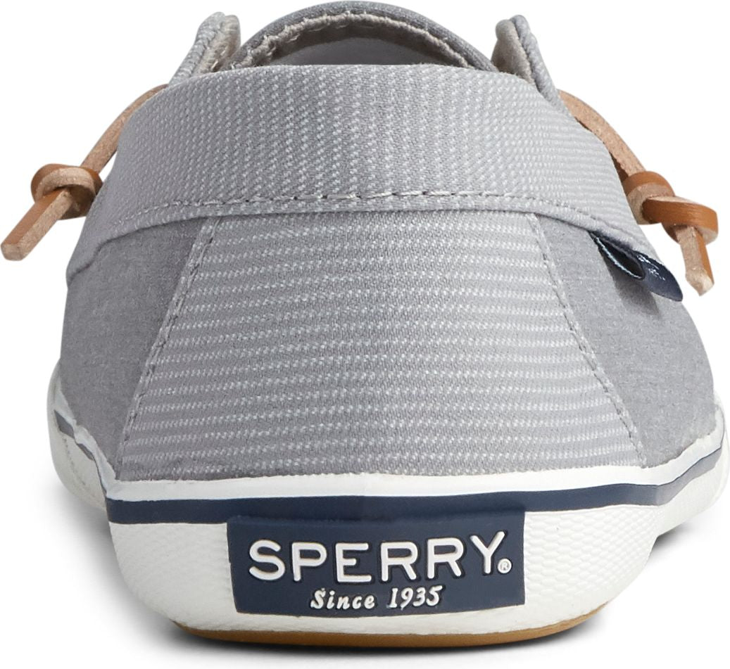 Gray slip-on shoe rear view; tag visible; laces tie at side; SPERRY Since 1935 text on heel.
