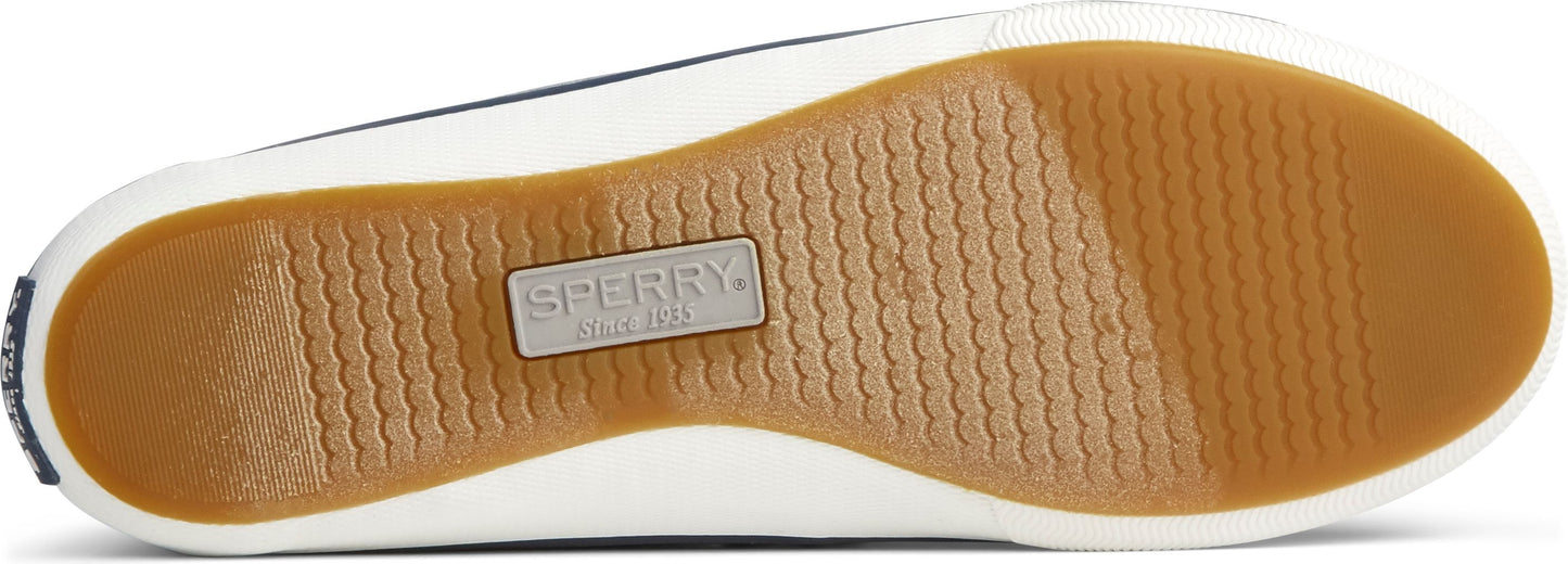 The sole of a shoe with a light brown rubbery material with a wavy pattern and a white trim.