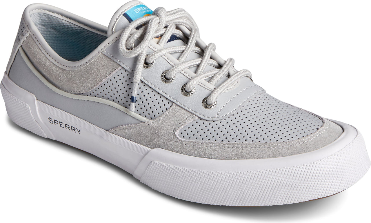 Low-profile lace-up sneaker in light gray suede and perforated leather with white sole, white laces and "SPERRY" logo on the side.