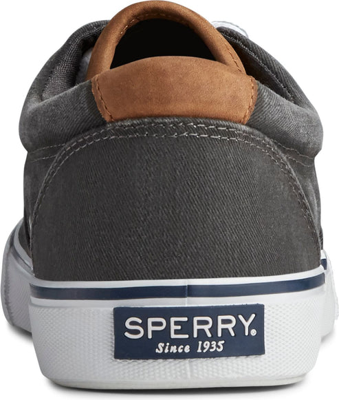 Close up of the back of a dark gray canvas shoe with brown leather heel accent and a white sole with blue stripe. The sole has 'SPERRY. Since 1935' in white text.