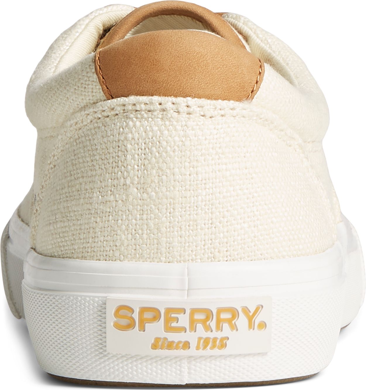 The back of a canvas cream colored shoe with leather heel accent and raised white sole with 'SPERRY since 1935' in tan text.