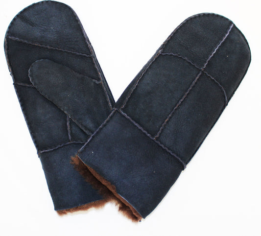 A pair of black sheepskin mittens with visible seams, showcasing the soft brown fur lining.
