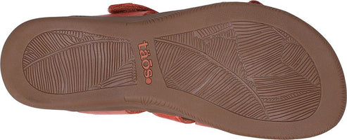 A sandal showing the sole with leaf pattern and the word 'Taos'.