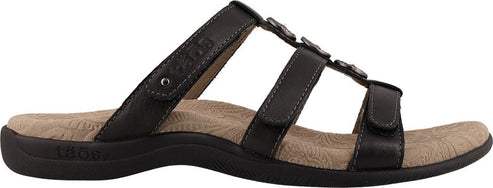A black sandal with three adjustable straps and the word "Taos" printed on the side.