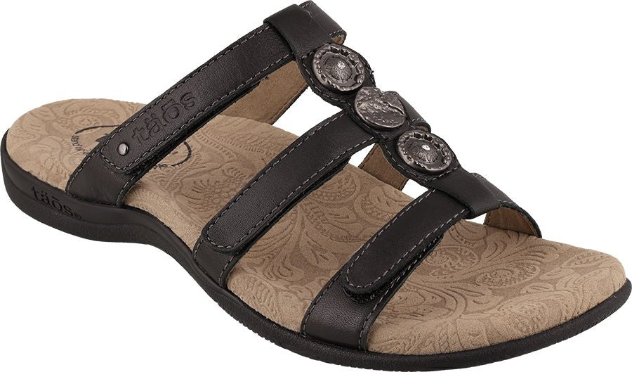 A black sandal with three straps across the top, each adorned with a decorative silver button.