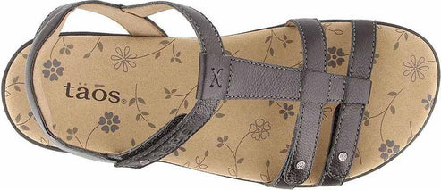 A brown sandal with multiple straps and a flower pattern on the insole, featuring the text "Taos".