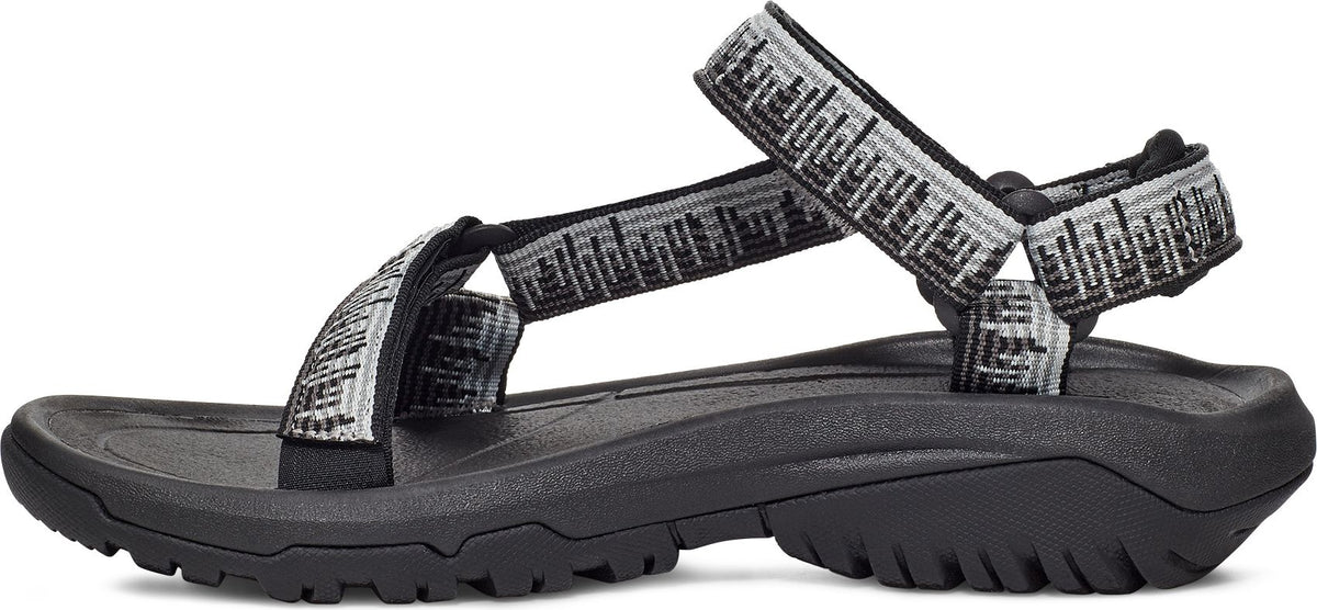 Side view of a black sandal with decorative straps.