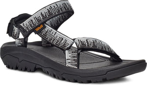 A sandal with black soles and gray-white patterned straps.