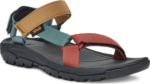 An angled, close-up of a black sandal with rust-colored, khaki, teal, and navy straps, and a "TEVA" tag.