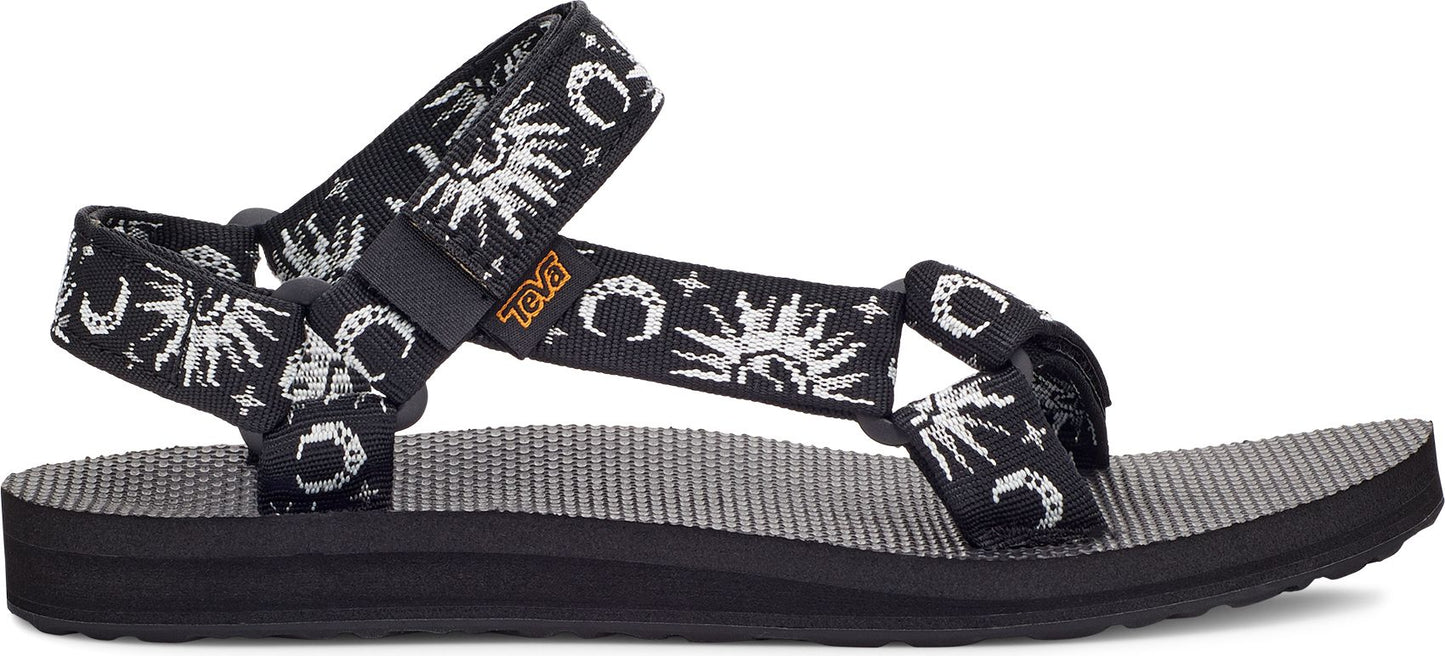A sandal with black straps patterned with white sun and moon designs.