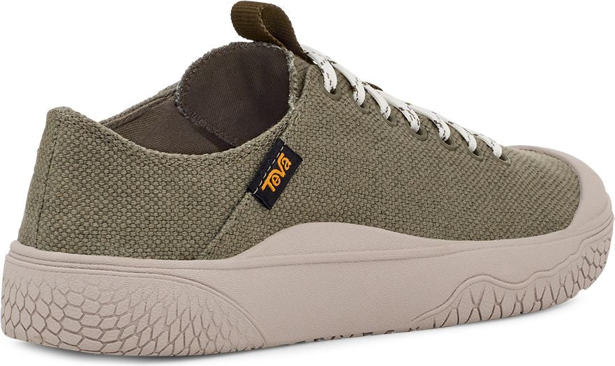 A low-profile olive green canvas shoe with off-white rubber sole and toe cap, white and black laces, and a brown Teva tag.