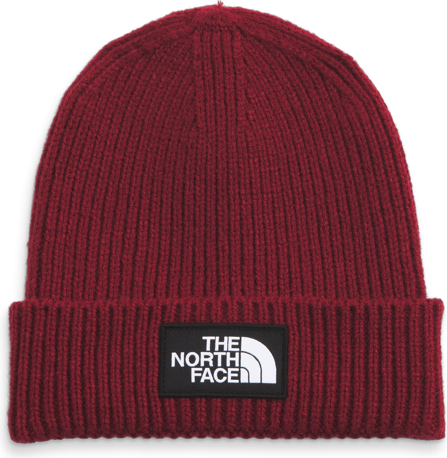 Red ribbed beanie with a black patch containing white text and a half circle shape.