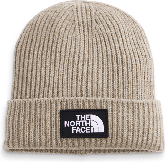Tan knit beanie with a black square patch with the words THE NORTH FACE in white text.