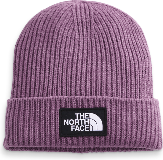 Close-up of ribbed knit beanie in light purple with rectangular black patch showing "THE NORTH FACE" in white lettering and a white half-dome symbol.