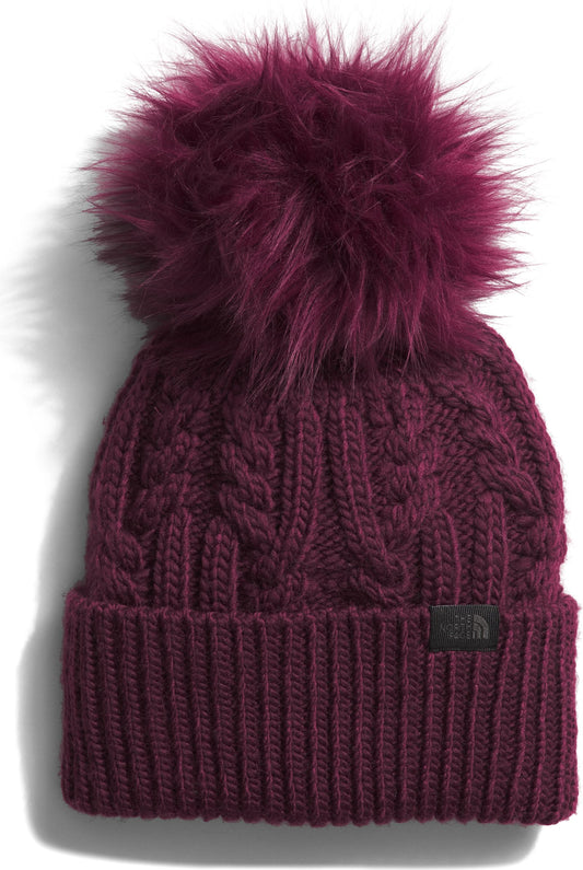 Close-up of a knitted beanie with a faux fur pom-pom.