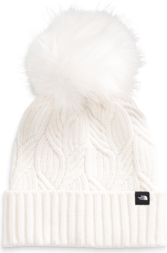 White knitted beanie with large pompom and black tag.