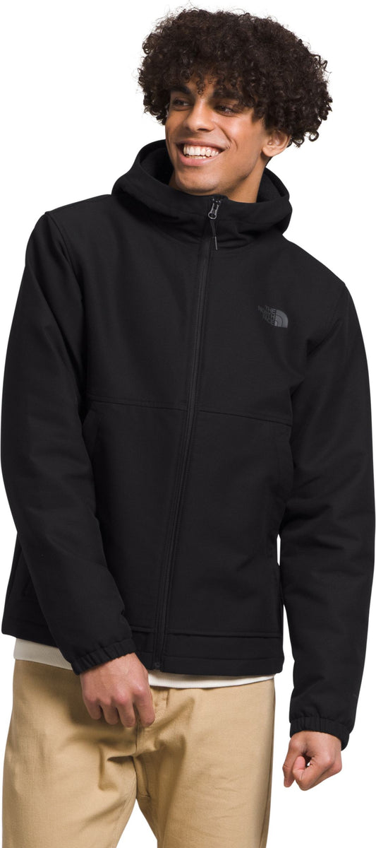 A person wearing a black jacket with a hood and khaki pants.