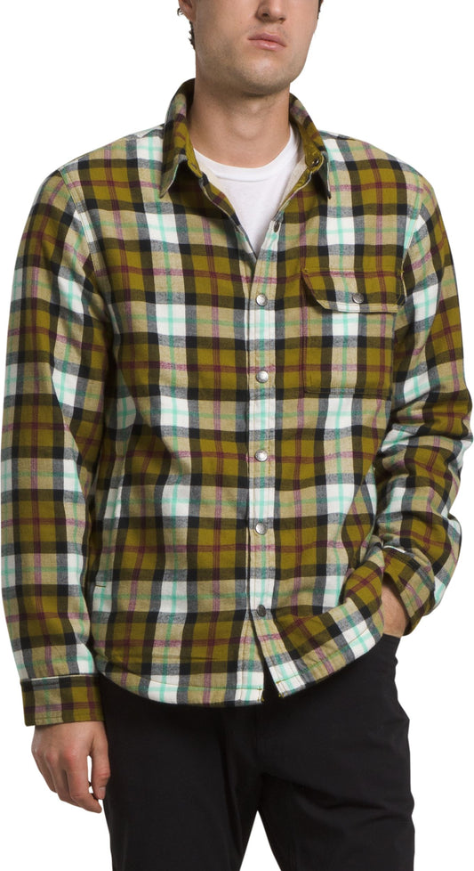 Man wearing a long-sleeved, buttoned, flannel shirt with a yellow, green, white, black, and red plaid pattern.