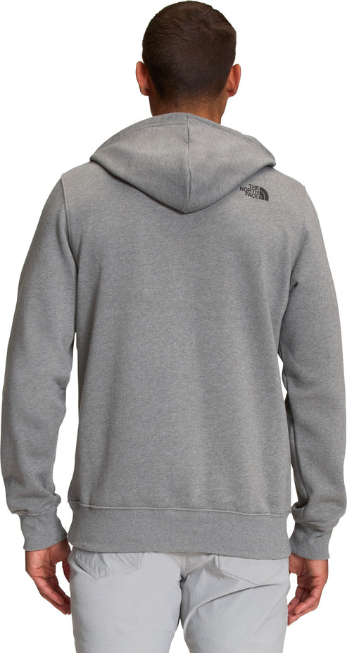 A person with brown hair wearing a gray hoodie with a hood, facing away from the camera, gray pants.