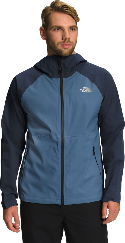A man wearing a blue and navy jacket with a hood.