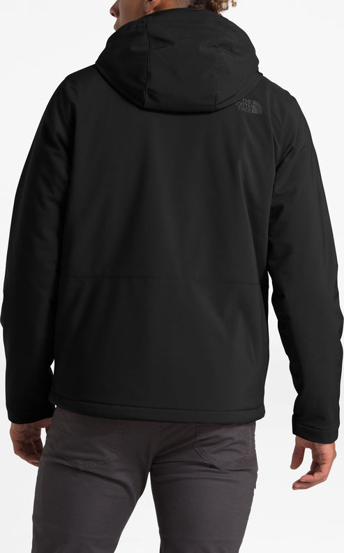 Back view of a person wearing a black hooded jacket and gray pants.