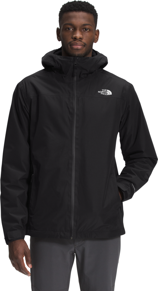 A man wearing a black hooded jacket with a zipper front.